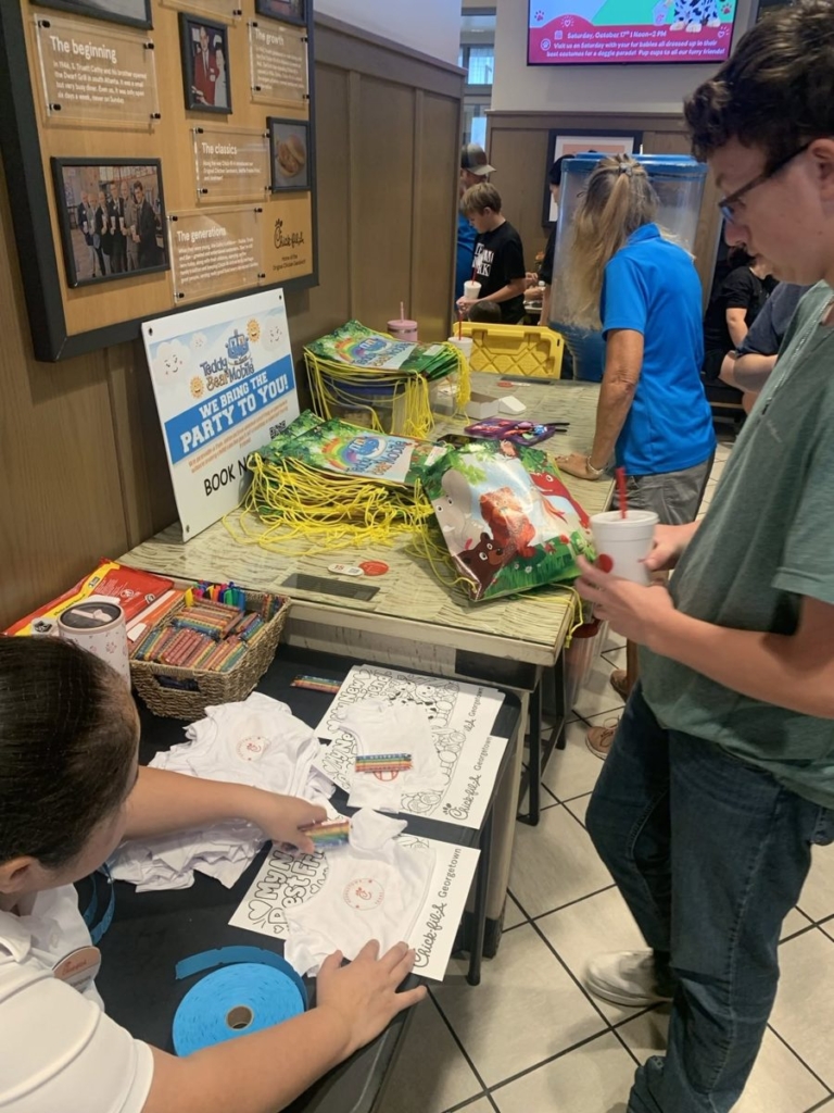 Teddy Bear Mobile table with drawstring bags and Chick-fil-A Georgetown shirts