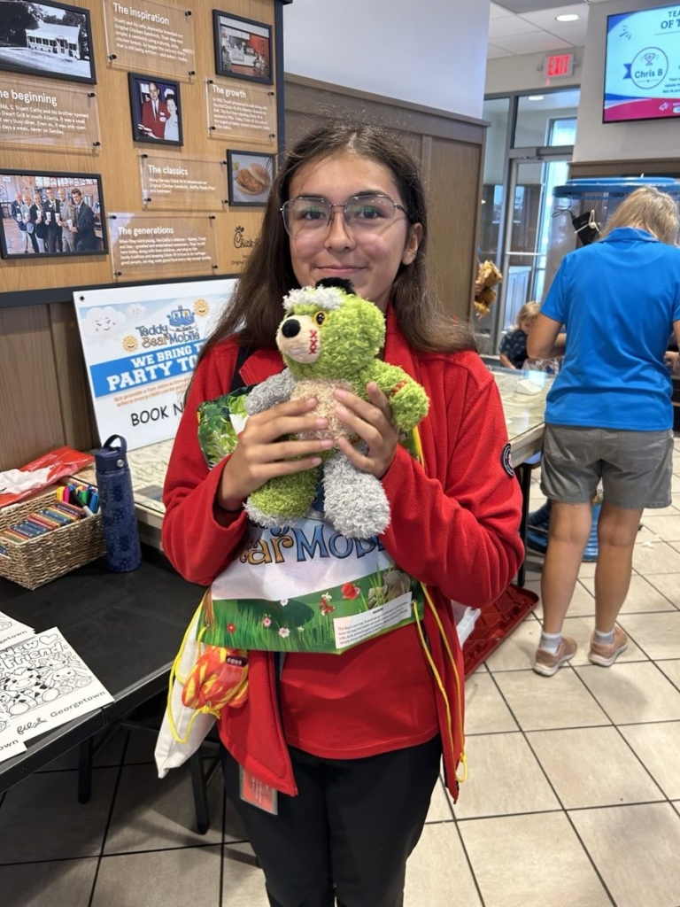 Teen holding a green bear made at Chick-fil-A Georgetown Kids Night