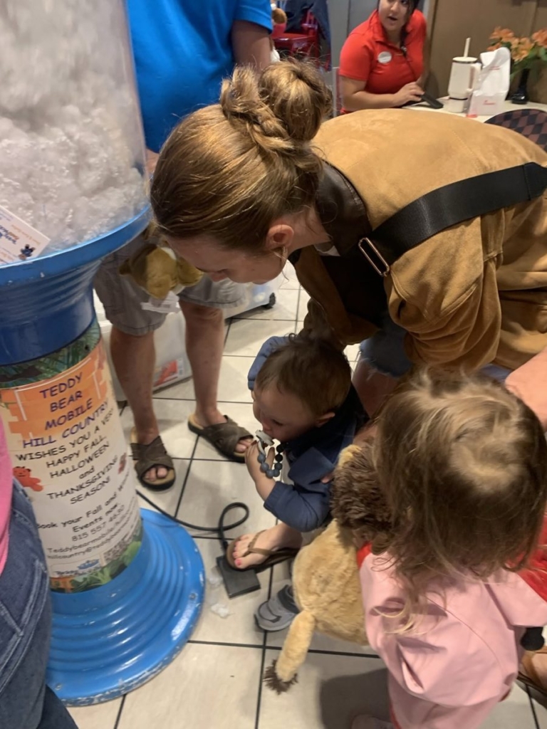 Mom helping two small kids pick their animals