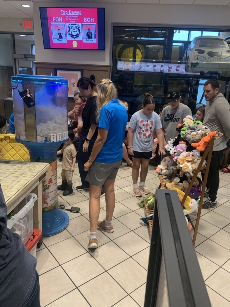 Families picking animals from the Teddy Bear Mobile rack